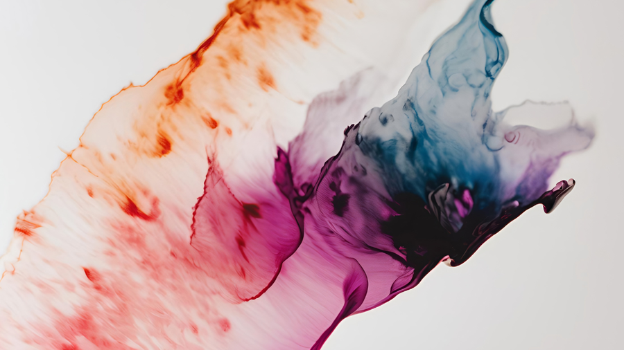 Orange, pink, purple, and blue color spreading through clear liquid.